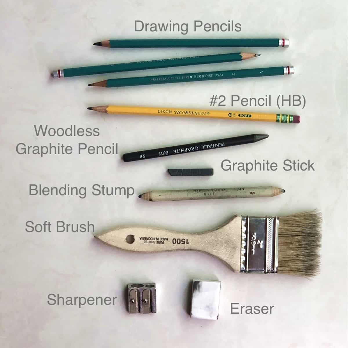 Different drawing and sketching tools including drawing pencils, woodless graphite, graphite stick, blending stump, brush for removing eraser dust, pencil sharpener and eraser.