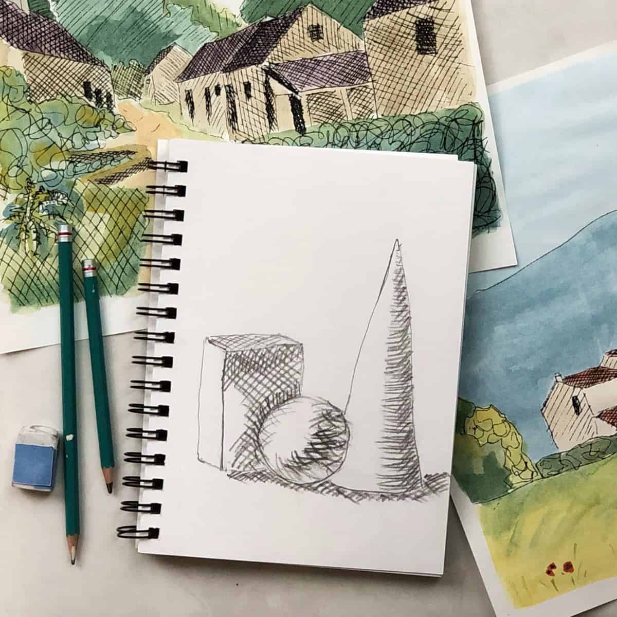 Crosshatching drawing of a cone, sphere, and box on a spiral notebook with colorful crosshatched watercolor paintings behind with drawing pencils and an eraser.