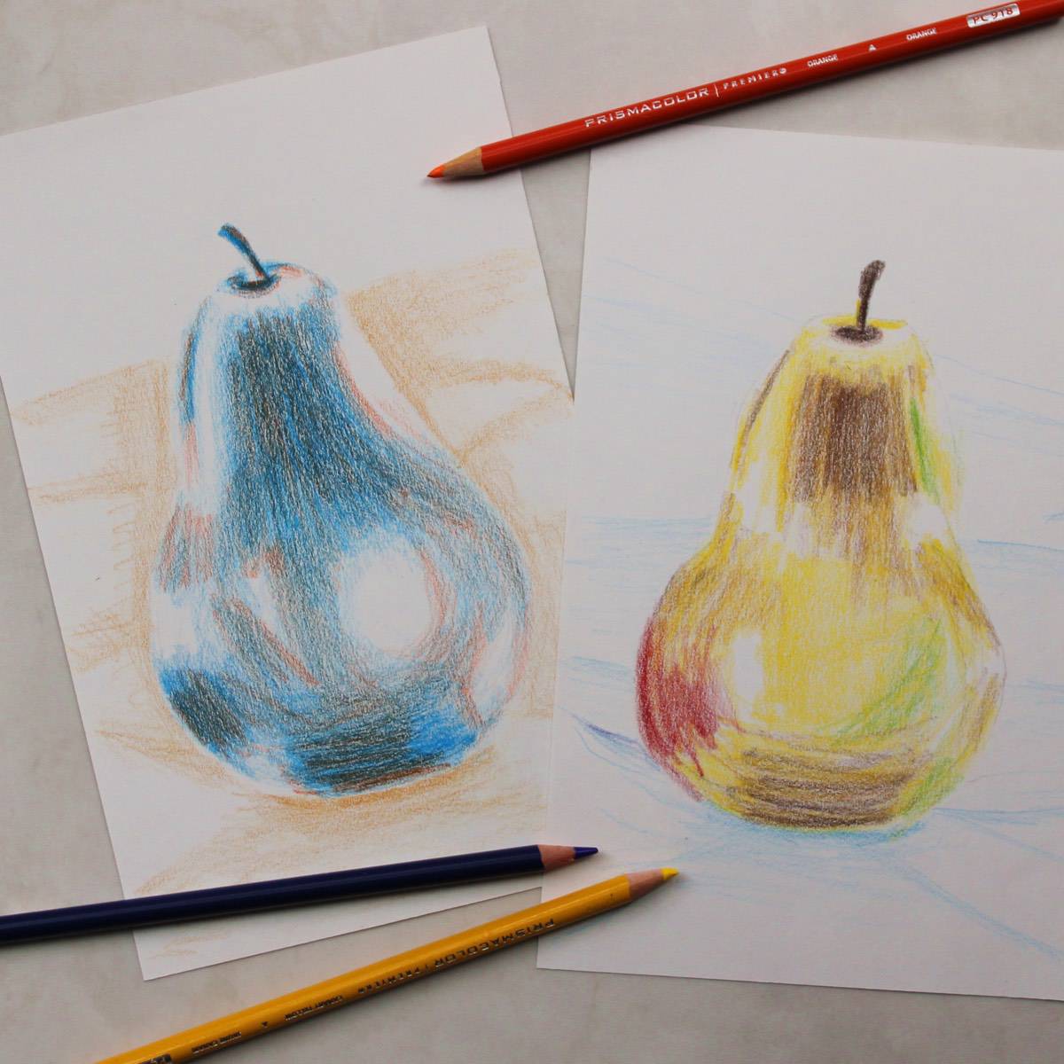 Colored pencil sketches of pears next to colored pencils.