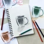 Drawing of a coffee mug in pencil with colored pencil drawings in the background.