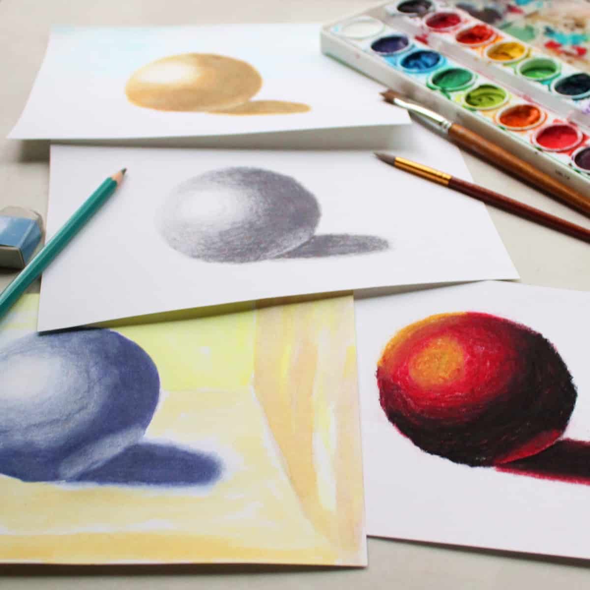 Drawings and paintings of spheres with watercolor paints, paint brushes and drawing pencil