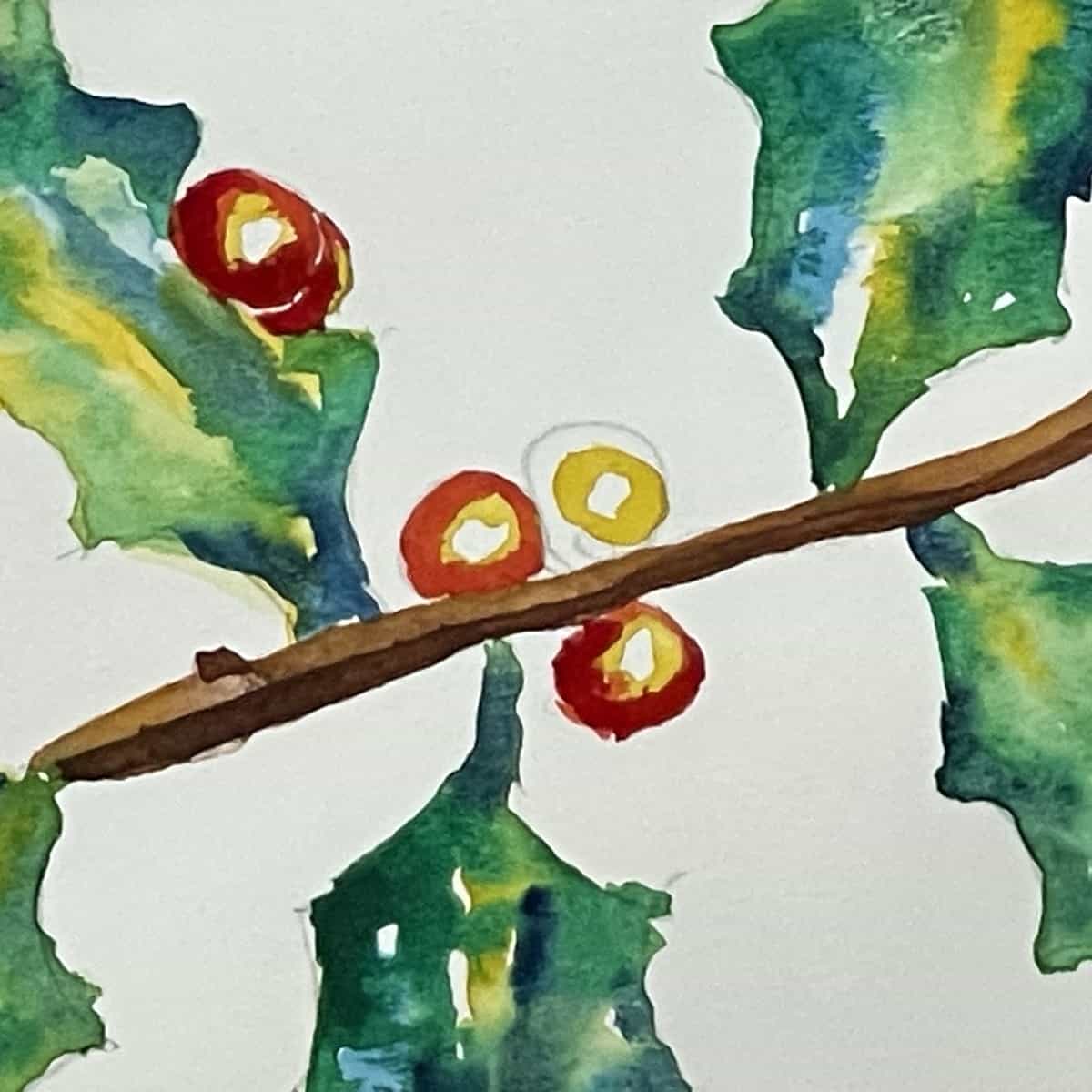 A watercolor painting of a sprig of holly, up close showing the process of painting red, yellow and crimson into the berries.