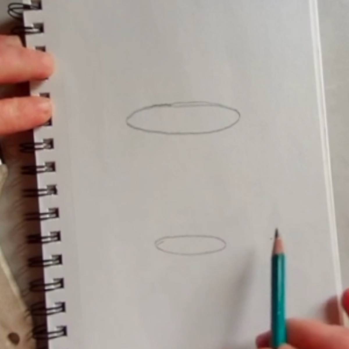 Beginning sketch of a coffee mug in pencil with two ovals one above the other.