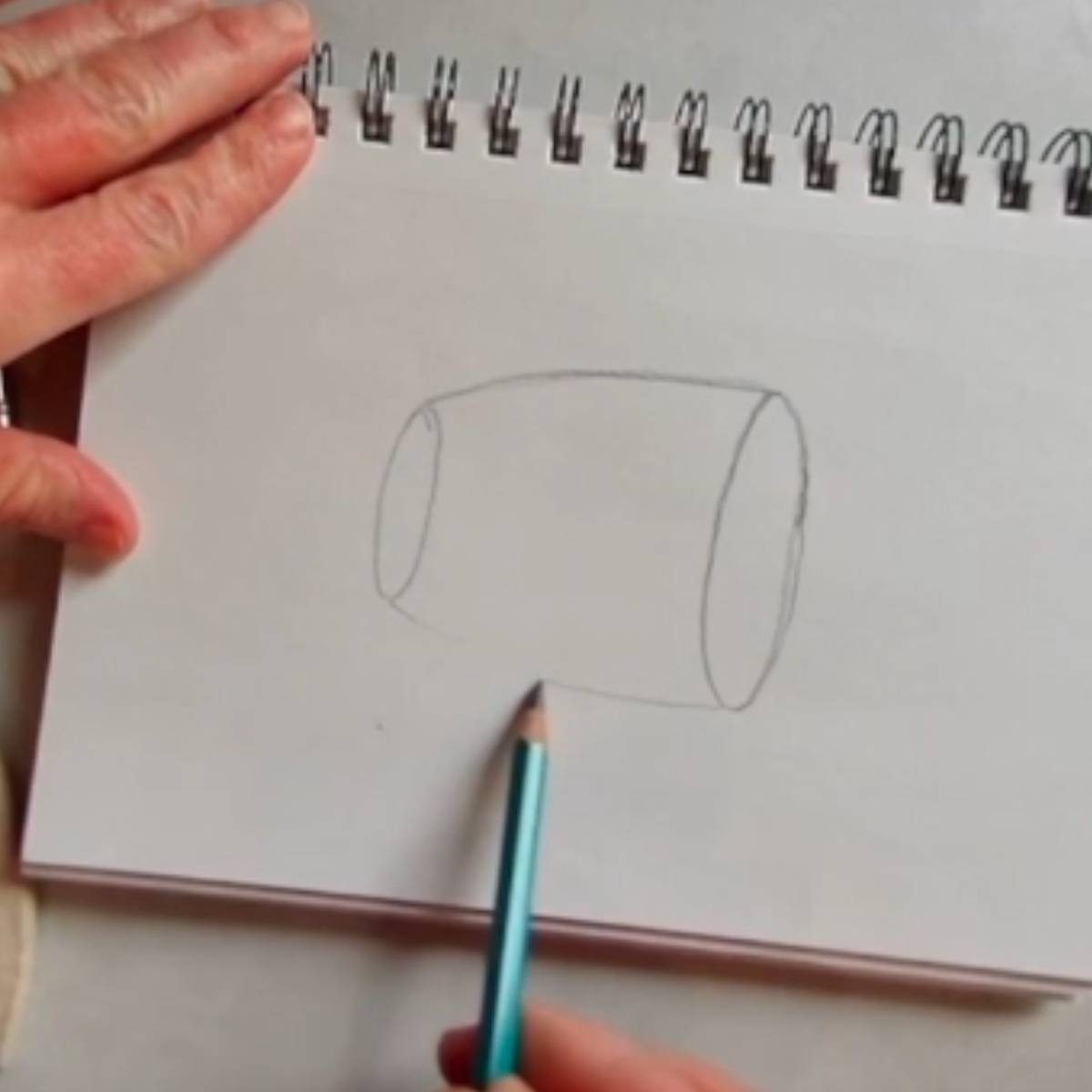 Beginning sketch of a coffee mug in pencil with two ovals with connecting lines for the sides of the mug.