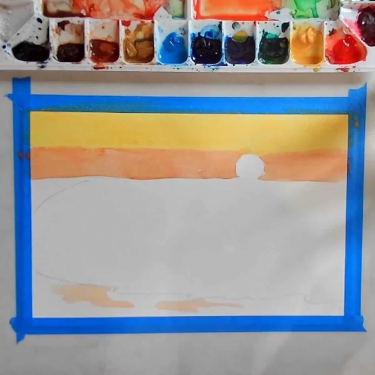 A watercolor painting in progress with orange and yellow in the sky.