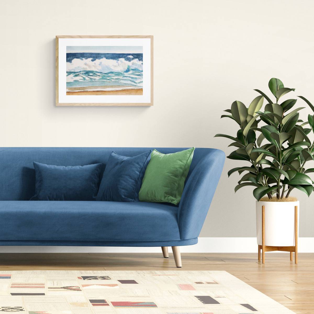 A framed painting of a seascape in a living room above a blue couch next to a plant.